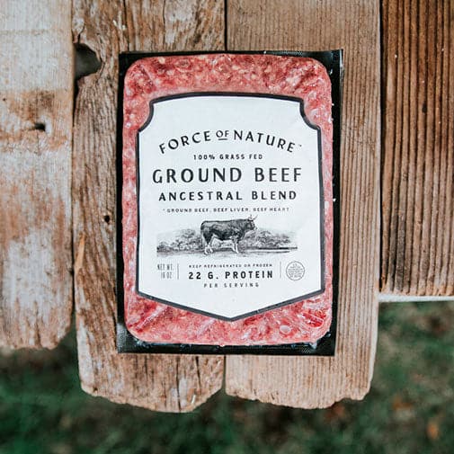 Pack of Force of Nature ground beef ancestral blend on wooden surface, containing grass-fed beef with liver and heart, 22g protein per serving.