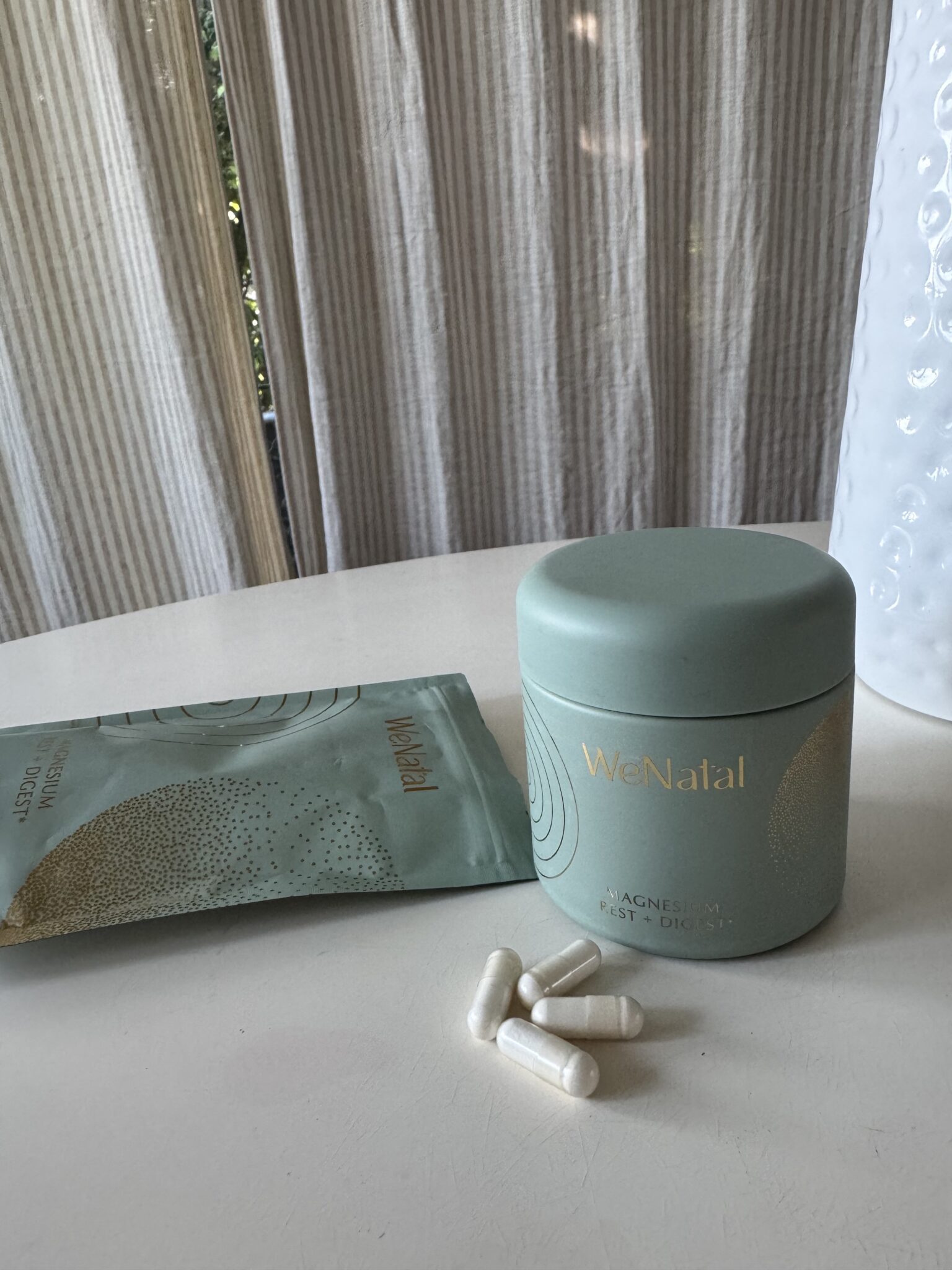 A bottle of medicine next to a packet of pills.