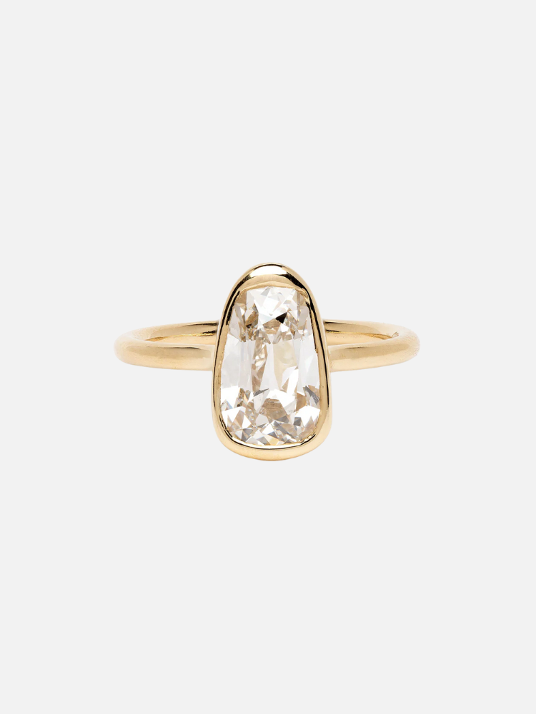Gold ring with a large, clear oval gemstone in the center, set in a simple band.