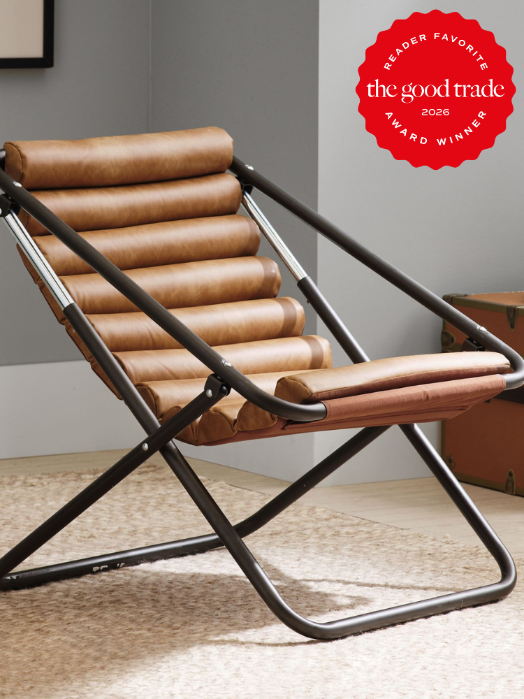 A brown leather and metal lounge chair sits on a beige rug in a modern room. A red badge in the corner reads "The Good Trade Reader Favorite Award Winner 2026.